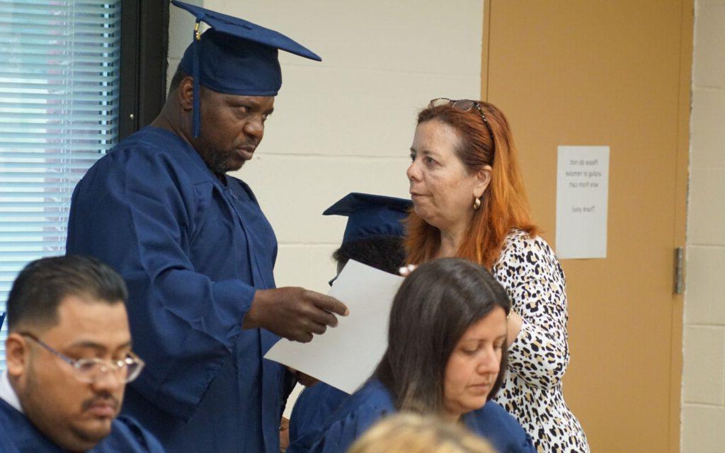 Woman speaking with man in a graduation cap and gown